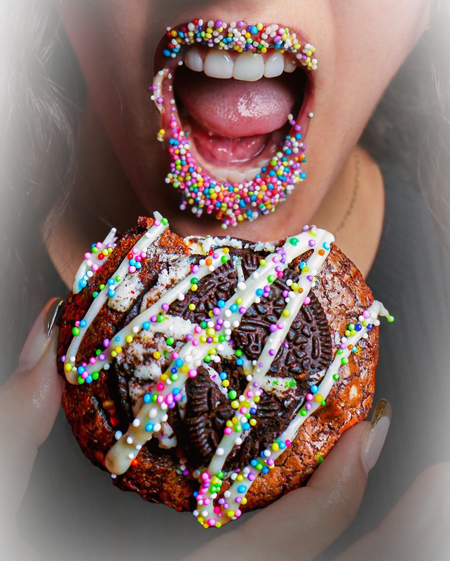 Yaz_mouth_web Girl with sprinkles on lips biting into a chocolate cookie with matching sprinkles and cream cheese drizzle